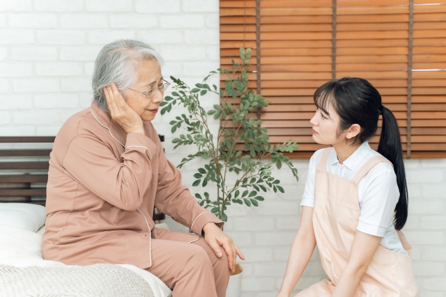 高齢者女性とエプロン姿の女性