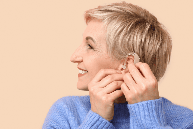 補聴器を取り付けようとしている女性