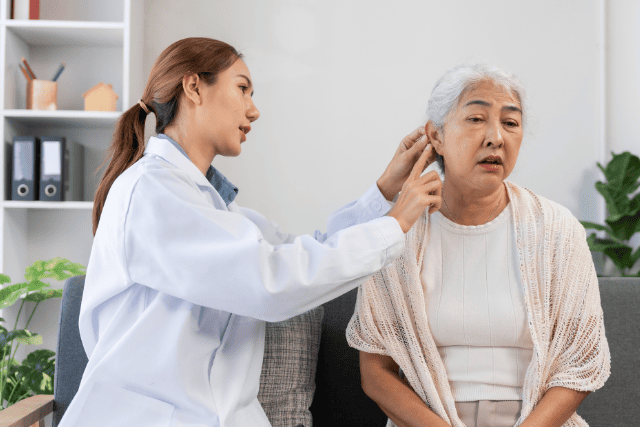 医者に耳を診察してもらっている女性