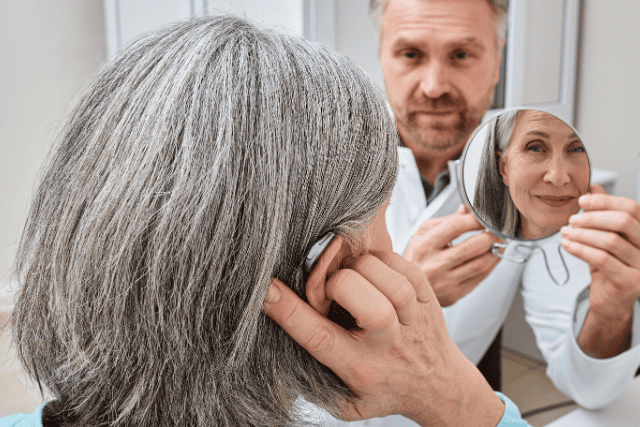 補聴器を装着している様子を見守りながらかか身を見せる医師