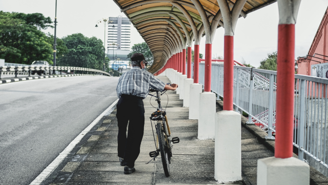 自転車を押して歩く老人の姿