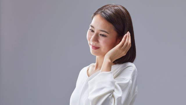 耳に手を添えている女性の様子