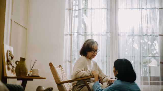 椅子に座る老人と若い女性が話している様子