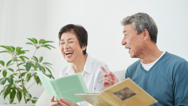 本を広げ笑いあっている老夫婦