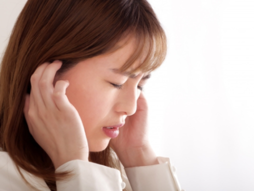 頭を抑える女性