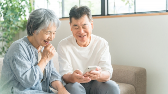 スマホを一緒に見るご高齢の男女